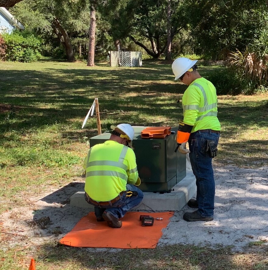 FPL crews connect power lines to a transformer box